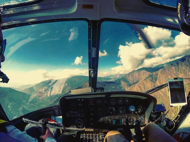       Interior view of a helicopter showing the landscape through windows.
  
