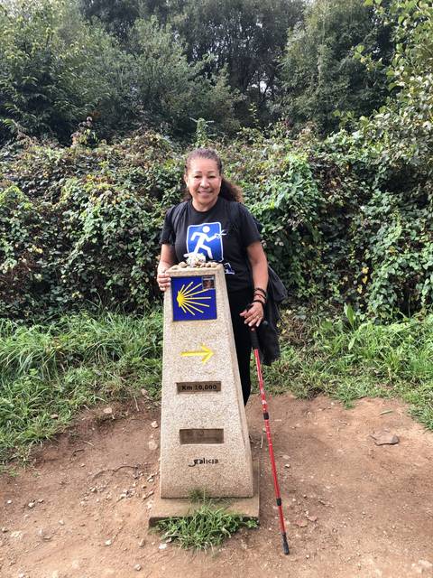 A person next to a walking milestone with symbols.