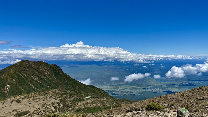       Panoramic view from a mountain peak with blue skies.
  
