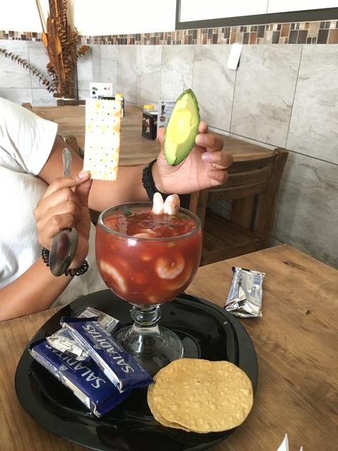       Shrimp cocktail with avocado slices and crackers.
  