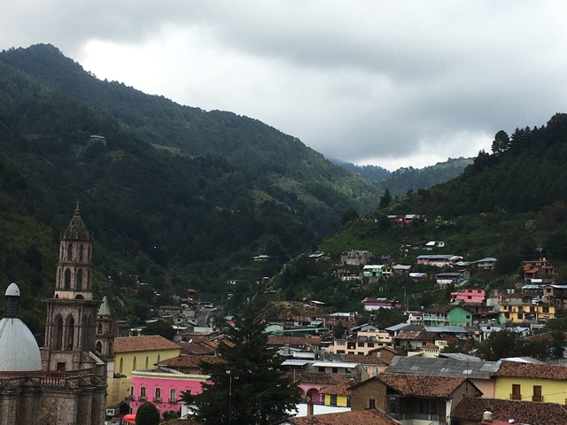      Mountainous village landscape with diverse houses.
  