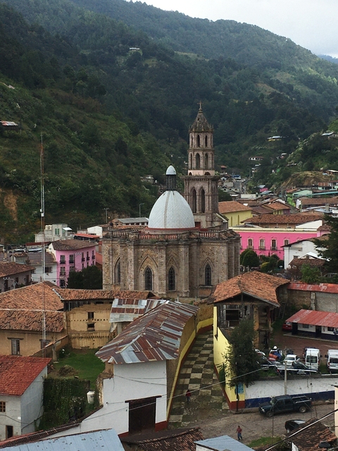       Cathedral dome with colorful buildings in a valley.
  
