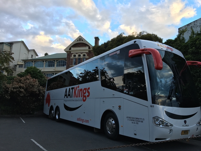A large tour bus parked outside a building.
