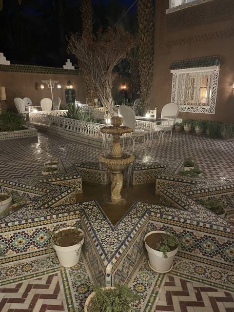 A courtyard with a central fountain featuring Moroccan tilework.