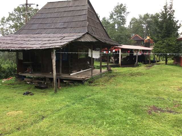      Rustic house and grass area with clothesline outdoors
  