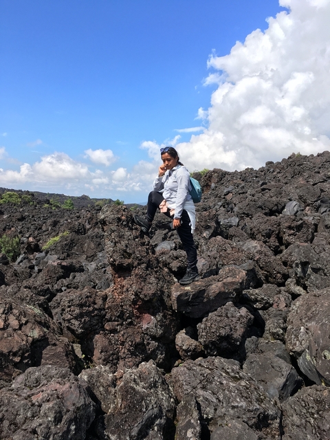      A person standing on a volcanic rock formation.
  
