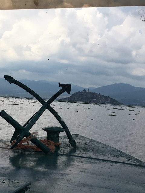       View of a mountainous landscape with a statue in the foreground.
  
