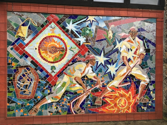       Colorful mosaic mural with figures and stars
  