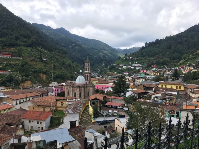       Mountainous town with church among lush greenery
  
