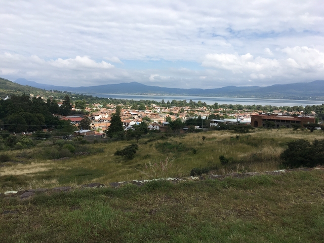       Aerial view of a town surrounded by lush mountains.
  