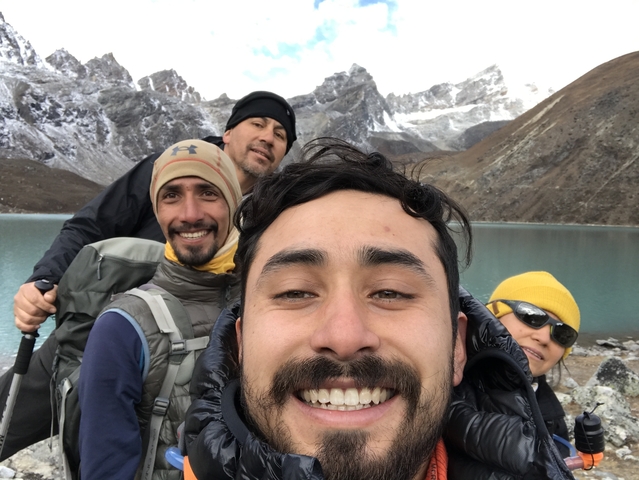 Group of hikers posing in front of a mountain lake.