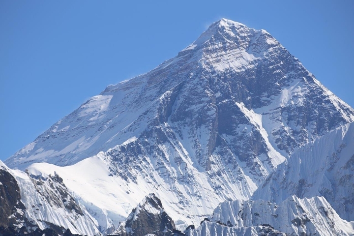       Snowy mountain peak under a clear blue sky.
  