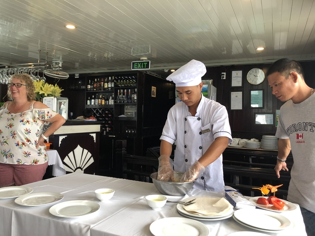       Cooking class on a boat with chef demonstrating.
  