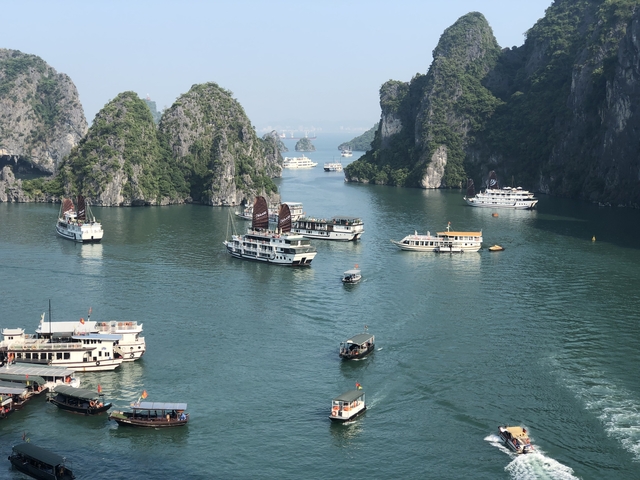 Halong Bay with cruise ships moored in calm water.