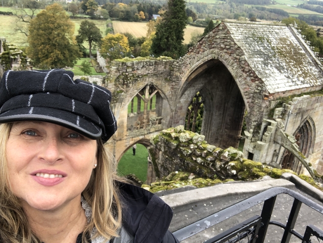       A person taking a selfie with ancient ruins in the background.
  