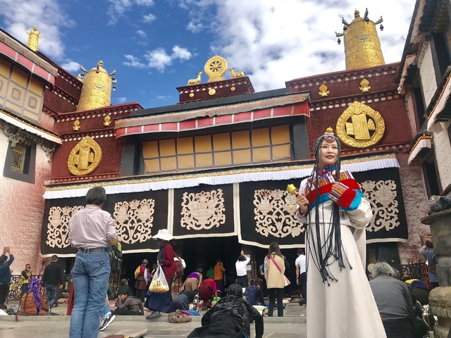 People in traditional dress outside a decorated building.