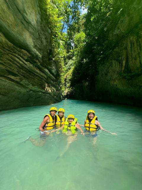       Group of people in a water activity wearing life jackets.
  