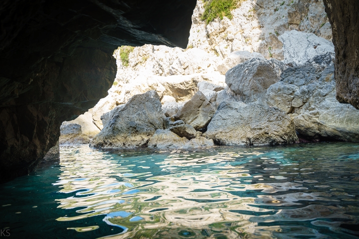 Rocky landscape with clear water inside a cave.