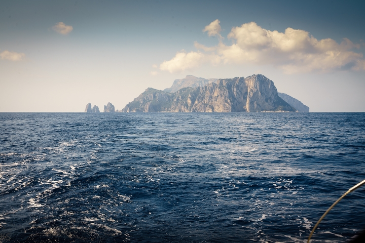 Island view from the sea with a clear sky.