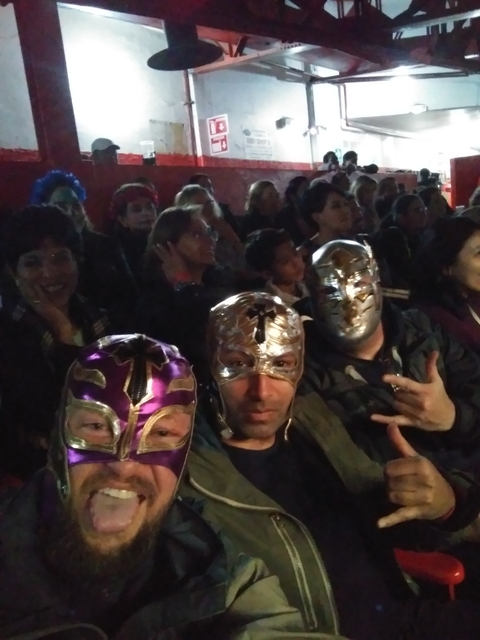       People wearing wrestling masks at an event.
  