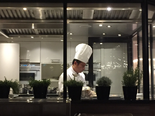 Chef in a kitchen preparing food, interior view.