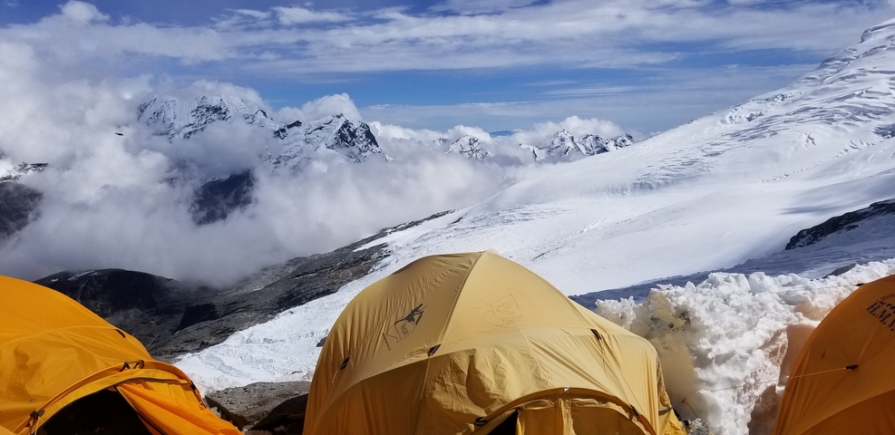       Yellow tents on a snowy mountain landscape.
  