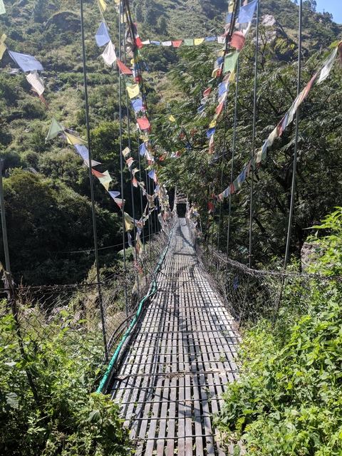 Suspension bridge decorated with prayer flags.
