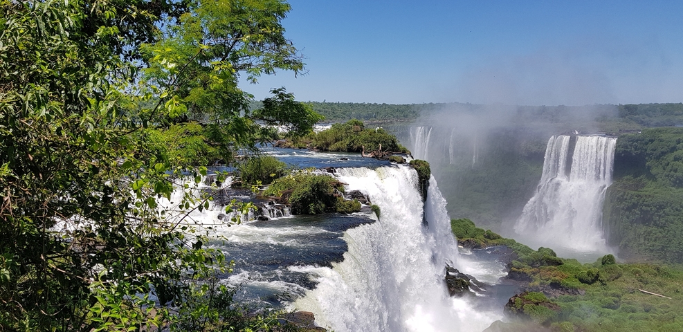 A vibrant view of Iguazu Falls with cascading water and lush foliage.