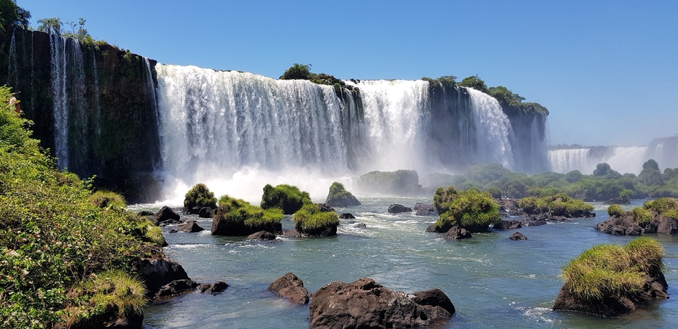 A view of Iguazu Falls from the river, showcasing the waterfall's powerful flow.