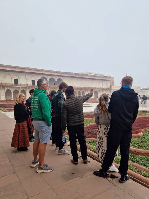       People at a historical site, viewing architecture.
  