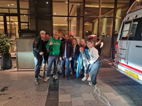      Group of people posing outdoors at night.
  