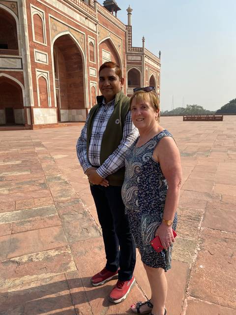       Two people posing in front of a building with intricate facade.
  
