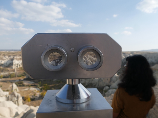       Viewing binoculars with a person in the background in a rocky area.
  