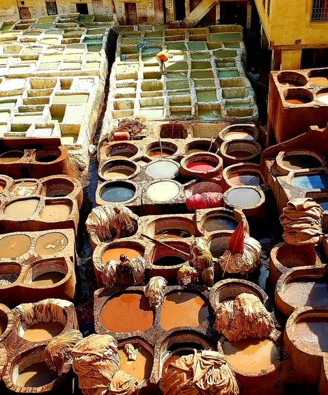       A vibrant image of traditional dye vats used for leather tanning.
  