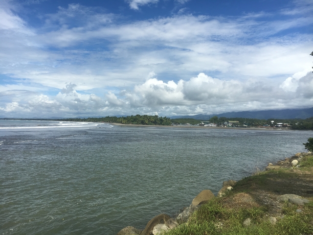 Panoramic view of a coastline with distant mountains.