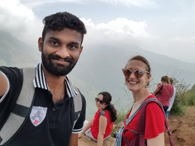 Group of four people taking a selfie on a mountain trail.