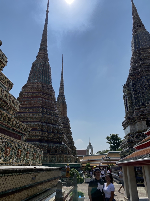       Ornate temple structures under a blue sky.
  