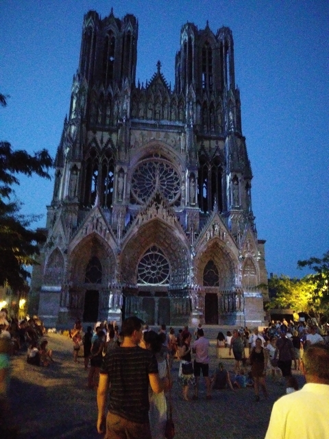       Gothic cathedral facade during twilight, lighting creating a blend of colors.
  