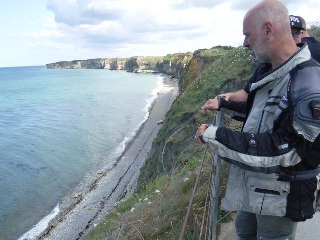       People overlooking a cliffside beach view.
  
