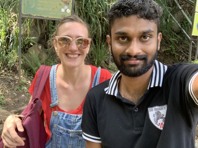 Two people posing together in a natural setting.