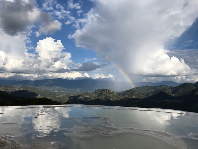 Stunning view of a landscape with a rainbow and mountains.