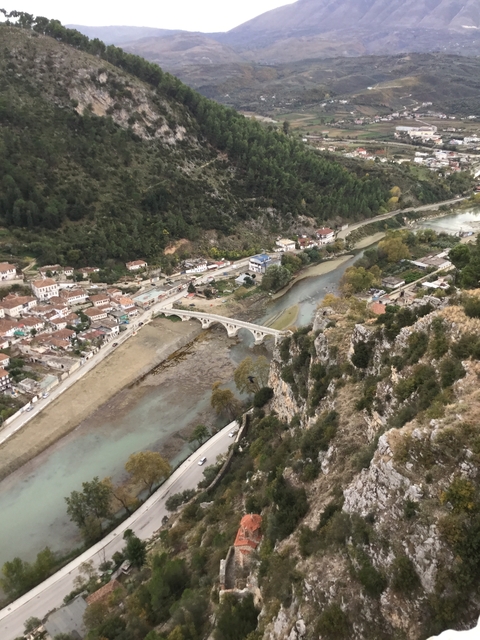 Aerial view of a historic bridge over a river with city buildings.