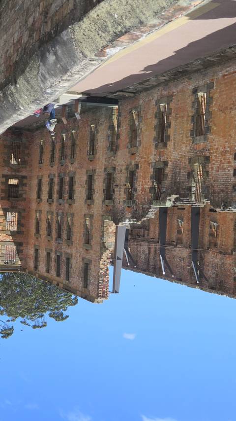 Historic brick building with people walking around.