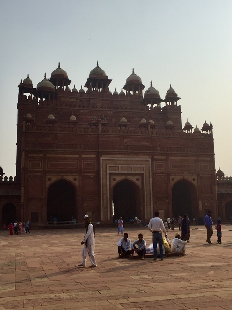 Historic gate with people walking in front.