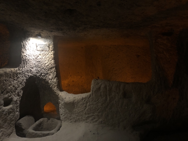       Dimly lit underground cave with carved signs.
  