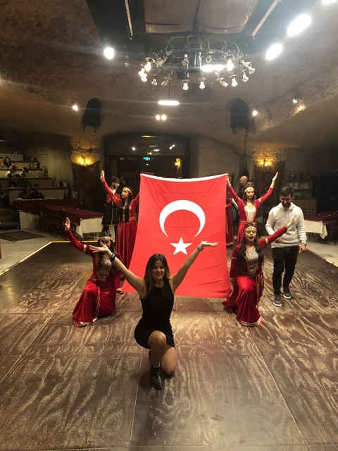       Individuals holding a Turkish flag in a performance.
  