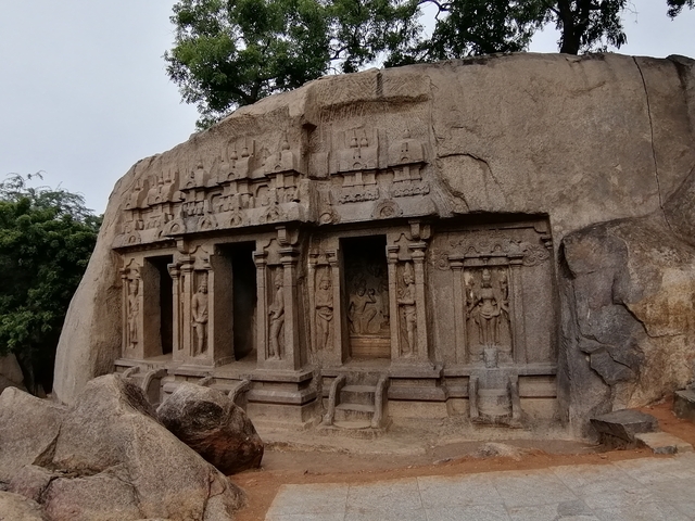 Rock-cut temple facade with intricate carvings.