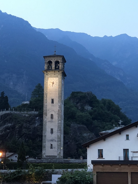 Clock tower against a mountainous backdrop