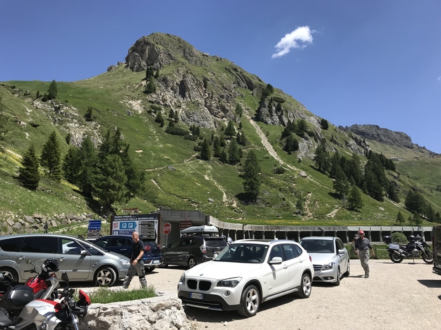 Mountain road with parked cars and people