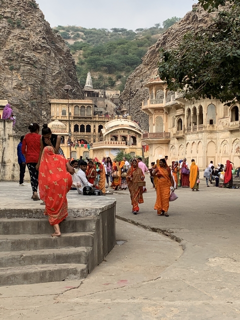       People in traditional attire near ancient temple.
  